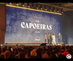 konferencja prasowa i gwizady serialu capoeiras na scenie na tle wielkiego ekranu z tytulem